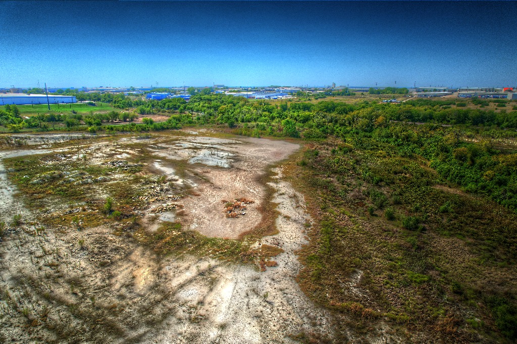 Elevated aerial overview of undeveloped land and surrounding development
